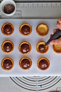 Tarte au chocolat sans gluten peu sucrée - Remplis les fonds de tarte de ganache au chocolat tiède.