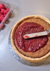 Tarte sans gluten frangipane pistache-amande et framboise - Étale la confiture de framboise sur la tarte cuite refroidie.