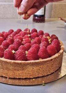 Tarte sans gluten frangipane pistache-amande et framboise - Parseme de pistaches concassées.