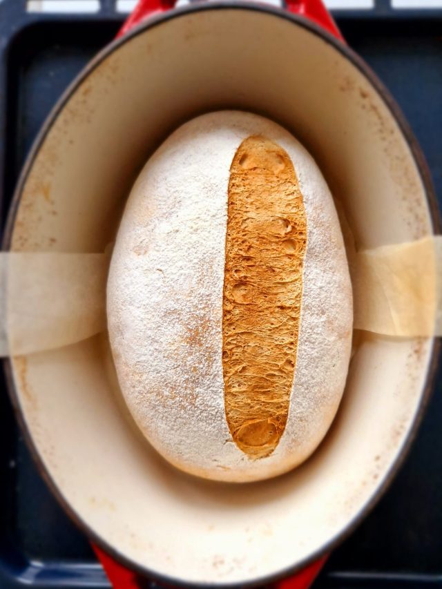 Pain sans gluten cuit dans une cocotte en fonte rouge