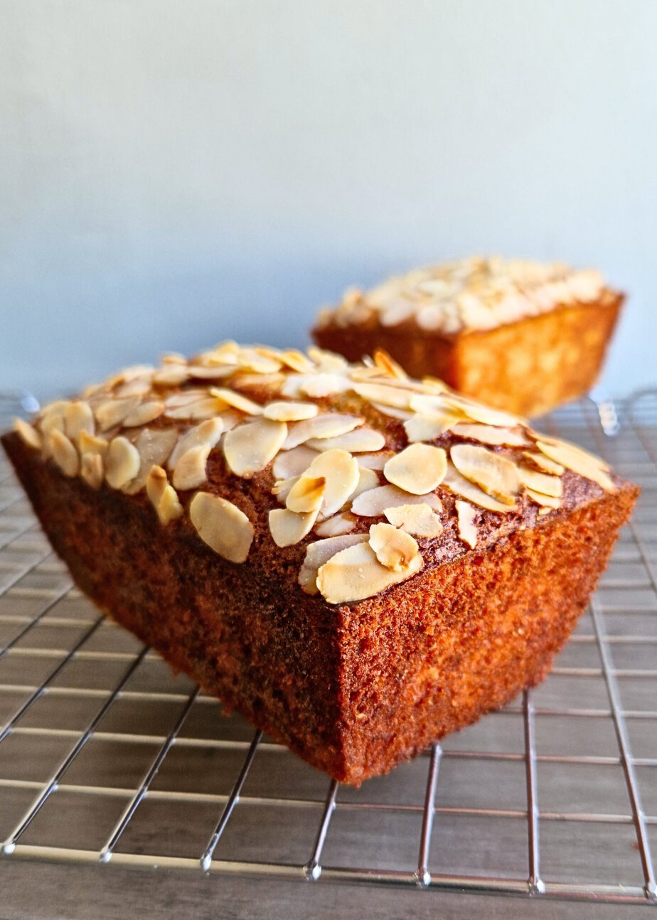 Deux cakes aux amandes effilées sur une grille, l’un très coloré, l’autre pâle