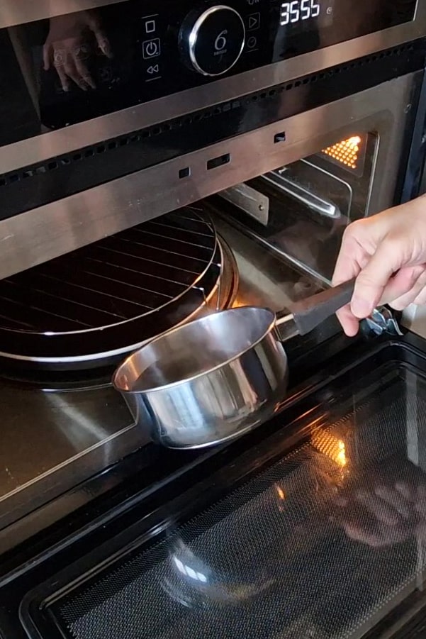 Casserole d’eau bouillante placée dans le bas d’un four pour créer de la vapeur