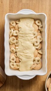 Crème versée sur les biscuits et les bananes