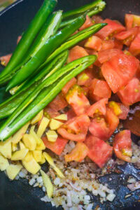 Crevettes au curry coco - Ajouter les feuilles de curry, le gingembre, les piments verts et les tomates.