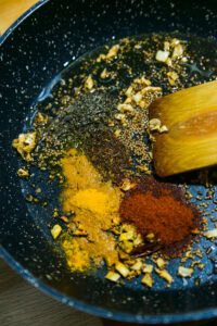 Dahl de lentilles corail - Retirer du feu, puis ajouter l'asafoetida, le piment de Cachemire, le curcuma et le garam masala.