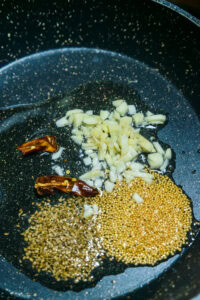 Dahl de lentilles corail - Ajouter les graines de moutarde, les graines de cumin, le piment rouge séché et l'ail.