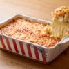 Mac and cheese américain gratiné, une portion soulevée à la cuillère