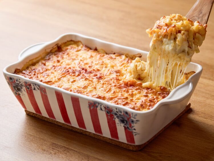 Mac and cheese américain gratiné, une portion soulevée à la cuillère