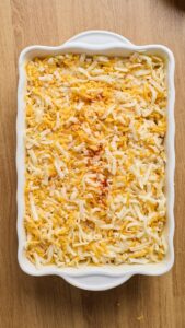 Mac and cheese dans le plat, fromage et paprika sur le dessus avant cuisson