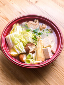 Mizutaki (fondue japonaise au poulet) - Ajouter les légumes dans l'ordre de leur temps de cuisson (chou, poireau, shiitakes, enokis, tofu, puis shungiku) et laisser mijoter jusqu'à tendreté.