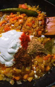 Poulet au curry - Baisser le feu, puis incorporer le yaourt, le piment de Cachemire, le garam masala et la coriandre en poudre.
