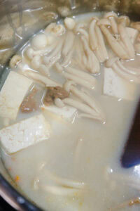 Tōnyū nabe - Quand le poulet est cuit, ajouter le lait de soja et le miso blanc mélangés.