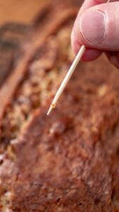 Cure-dent ressorti du banana bread avec quelques miettes humides