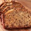 Tranches de banana bread moelleux devant le cake entier, sur une planche en bois
