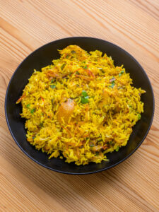 Biryani au poulet - Servir en prenant le biryani depuis le bord de la cocotte avec une petite soucoupe ou une spatule, pour ne pas casser les grains de riz.