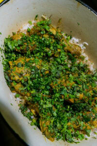 Biryani au poulet - Parsemer la moitié des herbes hachées et 2 à 3 cuillères à soupe des oignons frits réservés sur le poulet.