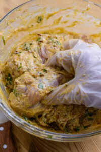 Biryani au poulet - Mélanger longuement avec les mains (avec des gants), jusqu'à ce que chaque morceau de poulet soit bien enrobé.