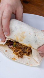 Burritos au bœuf - Rouler les tortillas en prenant bien soin de replier les extrémités vers l'intérieur, pour que la garniture reste enfermée.