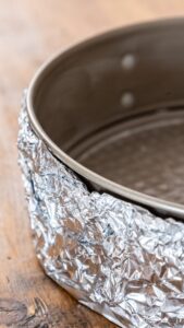 Moule à charnière graissé, le fond et les bords chemisés de papier aluminium