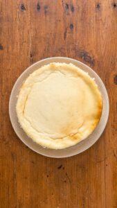 Cheesecake new-yorkais refroidi et démoulé, entier sur une assiette