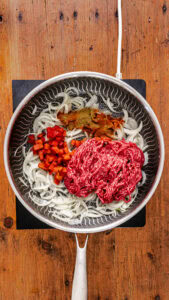 Chili con carne - Lorsqu'ils deviennent tendres, ajouter le cumin, le paprika, le piment de Cayenne, les dés de poivron, les haricots et le steak haché.