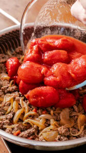 Chili con carne - Lorsque la viande commence à cuire, verser les tomates pelées avec leur jus.
