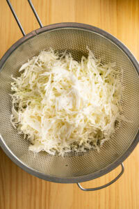 Coleslaw - Mettre le chou râpé dans un grand égouttoir.