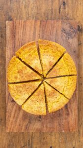 Cornbread démoulé sur une planche et coupé en huit parts