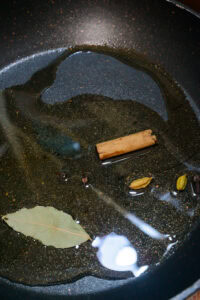 Curry de légumes - Ajouter la feuille de laurier, la cannelle, la cardamome et les clous de girofle, puis faire revenir.