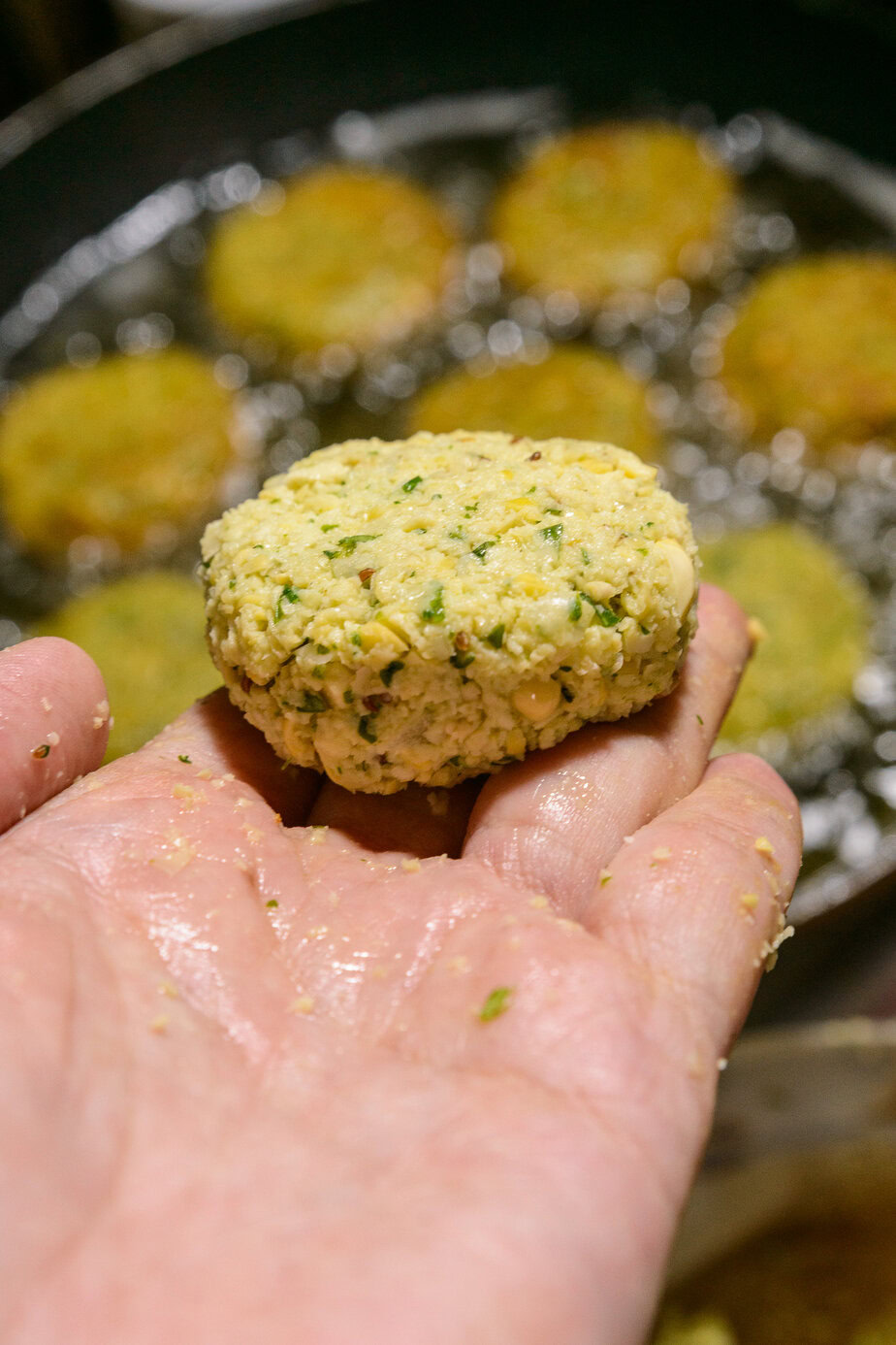 Falafel aplati entre les paumes, prêt à plonger dans l’huile