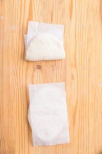 Gua bao - Plier chaque ovale en deux dans la longueur, en glissant un papier cuisson à l'intérieur.