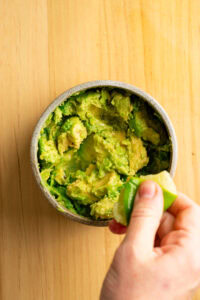 Guacamole - Presser le citron vert au-dessus de l'avocat.