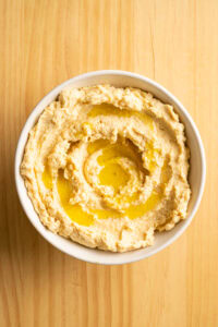 Houmous - Verser l'huile d'olive vierge extra dans le creux et sur la surface.
