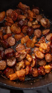 Jambalaya - Ajouter la saucisse fumée et la faire revenir 10 à 15 minutes, en remuant.