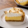 Part de key lime pie à la meringue dorée sur une assiette blanche