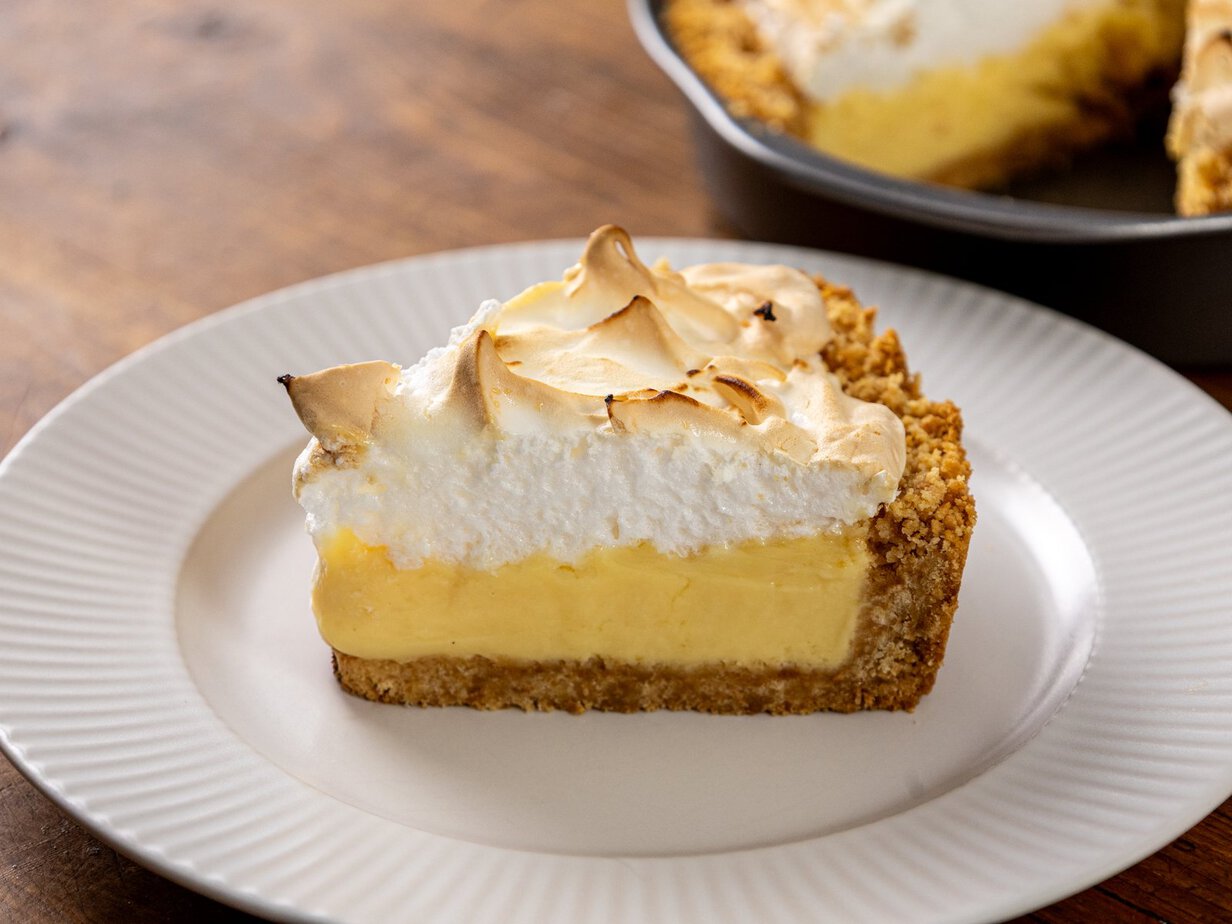 Part de key lime pie à la meringue dorée sur une assiette blanche