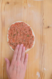 Lahmacun - En partant d'un bord, l'étaler du bout des doigts en appuyant, jusqu'à couvrir toute la pâte.