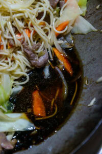 Lo mein - Verser la sauce directement sur la paroi du wok, pas sur les nouilles.