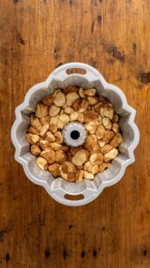 Morceaux de pâte enrobés disposés dans un moule à savarin beurré