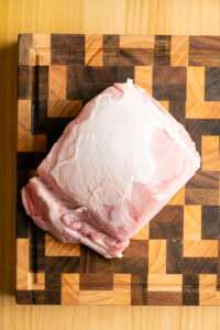 Pulled pork (porc effiloché) - Parer l'épaule de porc en retirant les gros morceaux de gras épais et dur, et laisser une couche d'environ 0.5 cm sur le dessus : elle fond à la cuisson et garde la viande moelleuse.