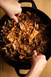 Pulled pork (porc effiloché) - Remettre la viande effilochée dans le jus de cuisson et mélanger pour qu'elle reste moelleuse.