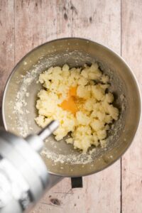 Œuf ajouté au beurre et au sucre crémés dans le bol du batteur