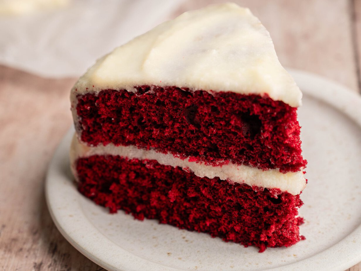 Part de red velvet à deux étages et glaçage ermine sur une assiette