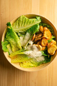 Salade César - Ajouter les croûtons et le fromage râpé.