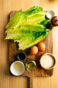 Salade César - Réunir sur le plan de travail, avant de commencer le montage, le sel, le poivre, l'huile d'olive, la sauce Worcestershire, le jus d'agrume, les œufs, le fromage râpé, les croûtons et les feuilles de romaine bien froides.