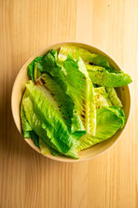 Salade César - Arroser du jus d'agrume et de la sauce Worcestershire.