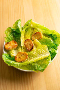 Salade César - Dresser les feuilles sur les assiettes, la tige vers l'extérieur, pour pouvoir les manger avec les doigts.
