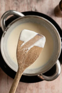 Sauce béchamel - Cuire à feu moyen environ 5 à 7 minutes, en remuant sans arrêt pour que la sauce n'accroche pas au fond, jusqu'à ce qu'elle épaississe et devienne lisse, brillante et assez épaisse pour napper le dos d'une cuillère.