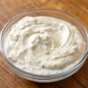 Sauce ranch maison dans un bol en verre, mouchetée de persil séché