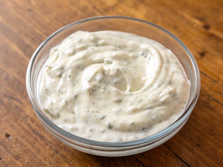 Sauce ranch maison dans un bol en verre, mouchetée de persil séché